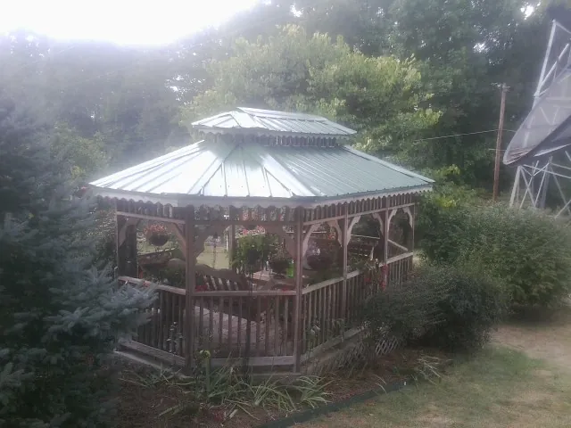 Green metal roof on a backyard gazebo surrounded by garden beds in Chesterfield